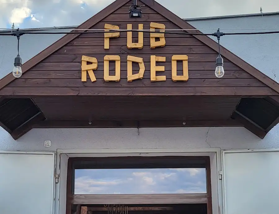 Wejście pod drewnianym szczytem z szyldem PUB RODEO